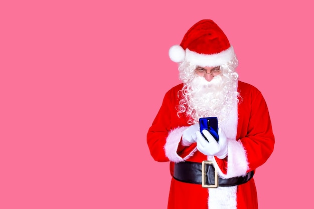 Engraçado velho barbudo Papai Noel de terno segurando um telefone celular