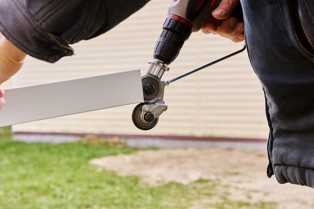 Los engranajes para cortar chapa metálica se giran utilizando un taladro eléctrico que es un adaptador adjunto Roofer corta el acero de techo al aire libre