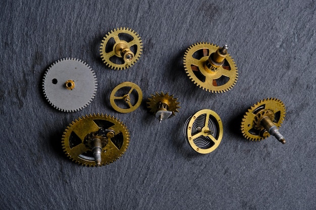 Foto engrenagens metálicas antigas de relógios mecânicos com fundo de pedra de ardósia