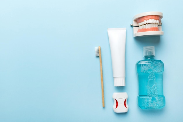 Enjuague bucal y otros productos de higiene bucal en la vista superior de la mesa de colores con espacio de copia Plano Higiene dental Kit de cuidado bucal Concepto de dentista