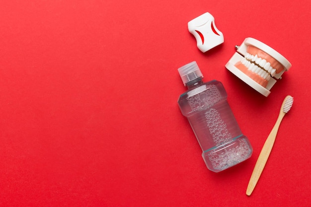 Enjuague bucal y otros productos de higiene bucal en la vista superior de la mesa de colores con espacio de copia Plano Higiene dental Kit de cuidado bucal Concepto de dentista