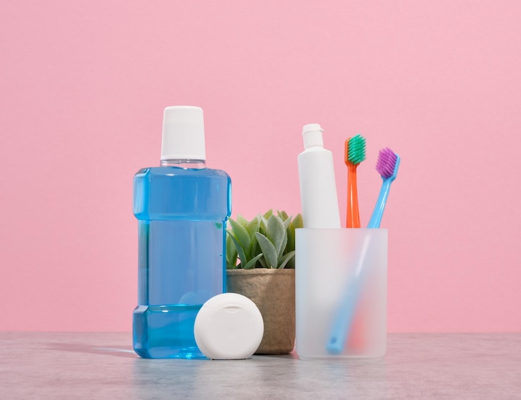 Enjuague bucal pasta de dientes y cepillos de dientes de colores brillantes hilo dental para el cuidado bucal Una planta en una maceta