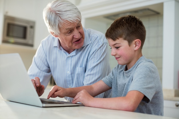 Enkel mit Laptop mit Großvater