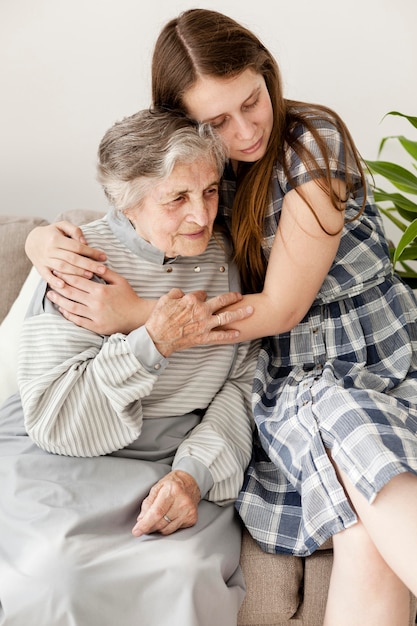 Enkelin, die Oma zu Hause umarmt