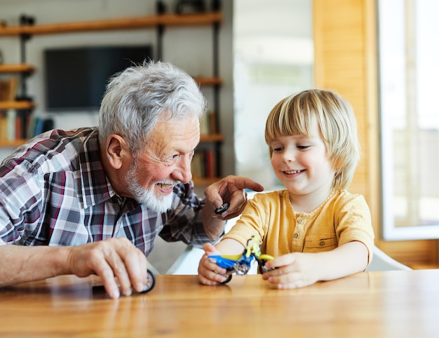 Enkelkind Familie Kind Großeltern Großvater Bildung Spielzeug Junge Spaß zusammen Senior Kind Enkel glückliches Zuhause umarmt Bindung Ruhestand