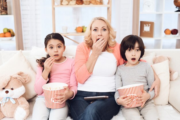 Enkelkinder schauen sich mit Oma einen gruseligen Film an