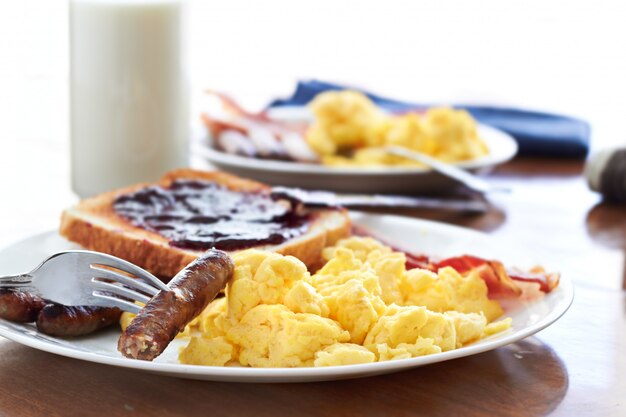 Los enlaces de salchicha se recogen con un tenedor en un gran desayuno.