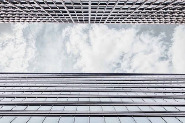 Enmarcado con la fachada del edificio de oficinas desde abajo hacia arriba con una franja horizontal de cielo gris con nubes. Centro de negocios en un día nublado