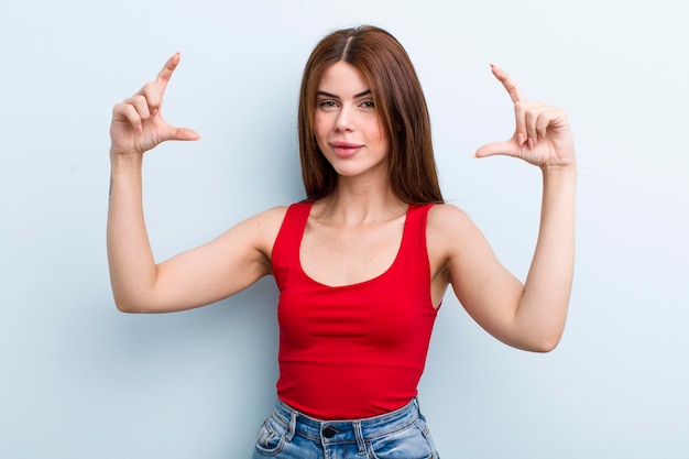 Enmarcar o delinear la propia sonrisa con ambas manos mirando un concepto de bienestar positivo y feliz