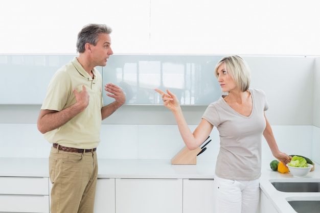 Enojado pareja discutiendo en la cocina