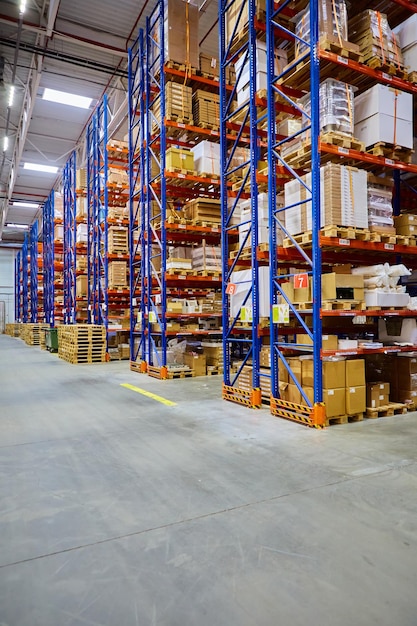 Enorme almacén de distribución con estantes altos y cargadores.