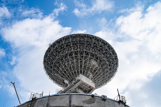 Enorme antena parabólica para comunicação e recepção de sinais do planeta Terra. Observatório em busca de sinal de rádio no espaço ao pôr do sol.