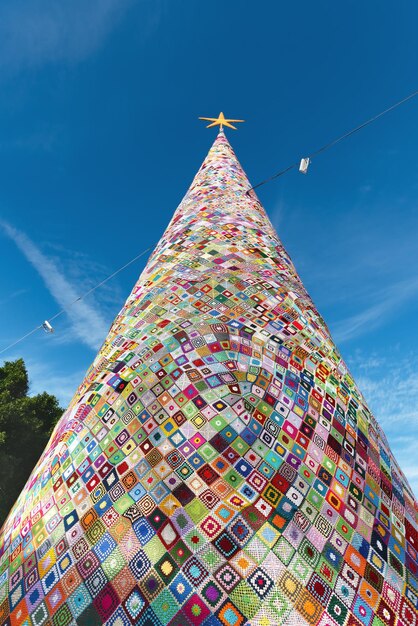 Foto un enorme árbol de navidad creado a partir de cuadrados de abuela tejidos al ganchillo hechos con lana colorida