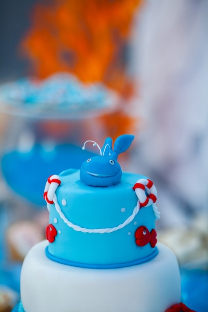 Foto enorme bolo de aniversário azul e branco com doce caranguejo, peixe, estrelas do mar e baleia engraçada no topo