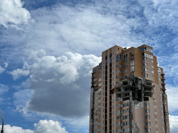 Enorme buraco no prédio de apartamentos após o bombardeio durante a guerra dramática céu nublado no fundo