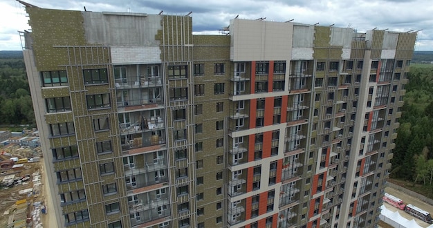 Un enorme edificio de apartamentos con un bosque detrás.