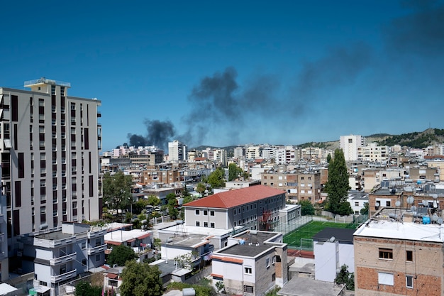 Enorme fumaça preta na cidade ensolarada.