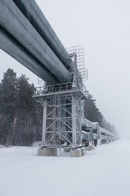 Foto enorme gasoduto colocado ao longo de uma rua nevada em riga, na letônia