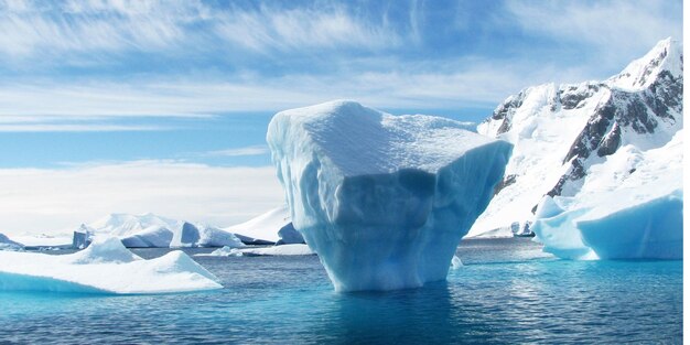 Foto un enorme iceberg flotando en las claras aguas azules del océano ártico