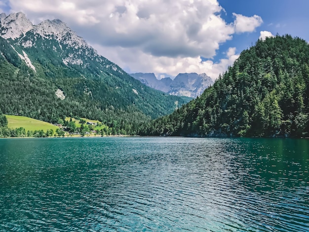 Foto enorme montaña azul lago intacto vida silvestre de europa majestuosas montañas cubiertas de árboles se elevan por encima de