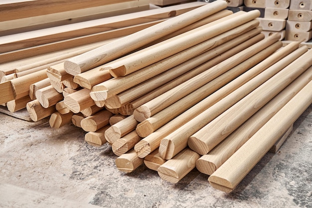 Enorme pilha de barras de madeira feitas de material maciço de faia encontra-se na oficina de carpintaria contemporânea