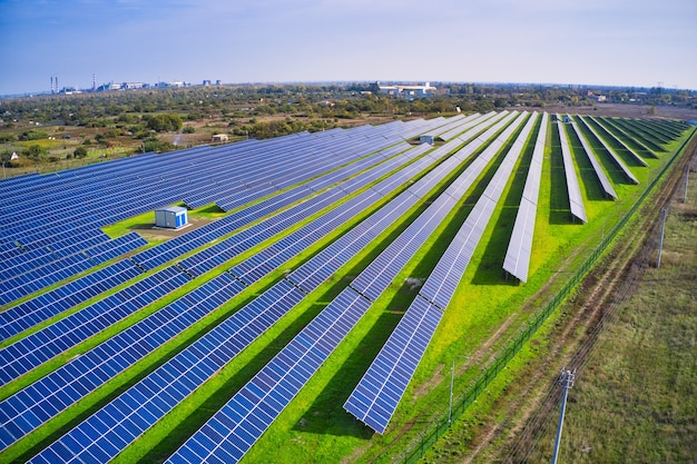 Enorme planta de energía solar para utilizar energía solar en un pintoresco campo verde en Ucrania. Disparo de drone panorámico aéreo