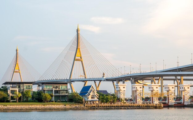 Enorme puente letra tailandesa significa nombre 'Bhumiphol' cruza el río Chaophraya en el cielo crepuscular de la tarde de Bangkok