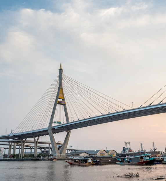 Enorme puente letra tailandesa significa nombre 'Bhumiphol' cruza el río Chaophraya en el crepúsculo vespertino de Bangkok