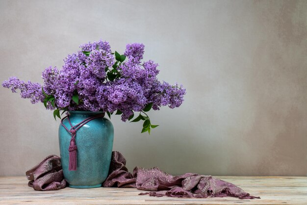 Un enorme ramo de lilas en un gran jarrón aislado en un fondo claro naturaleza muerta con flores mucho espacio para el texto