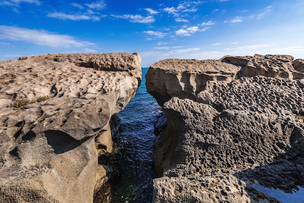 Foto una enorme roca en la orilla en forma de arco.