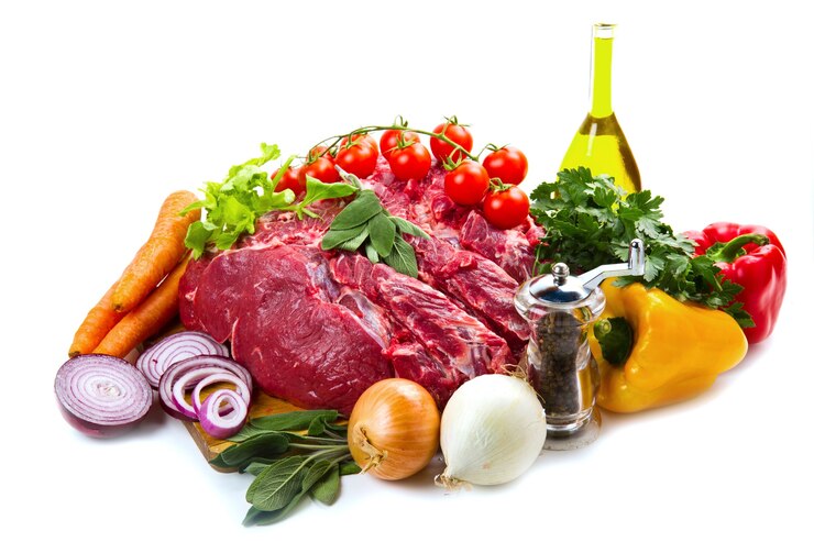 Enorme trozo de carne roja con verduras aislado sobre fondo blanco.