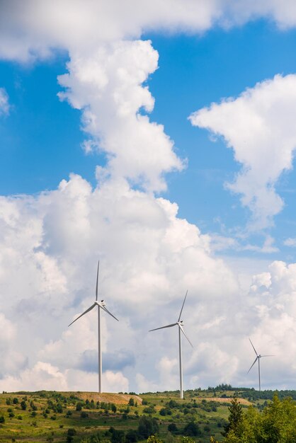 Enormes molinos de viento en las montañas en el fondo del cielo nublado