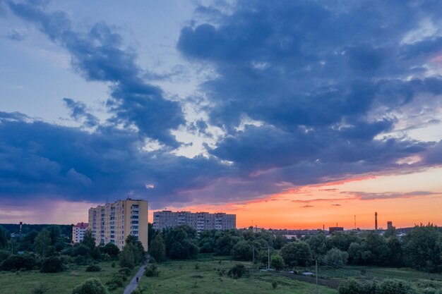 Foto enormes nuvens sobre um bairro residencial ao pôr-do-sol entre árvores na natureza um belo crepúsculo