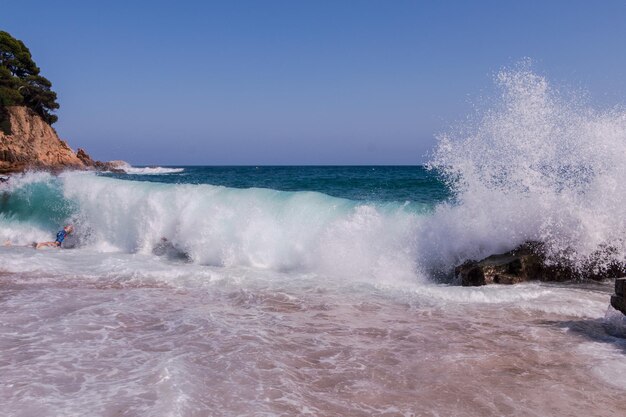 Enormes ondas batem contra as rochas na praia de Fenals em Lloret de Mar Catalonia