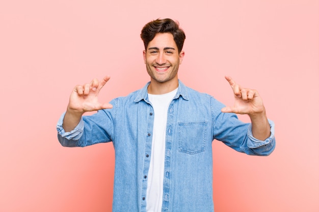 Enquadrar ou delinear o próprio sorriso com as duas mãos, olhando positivo e feliz, conceito de bem-estar