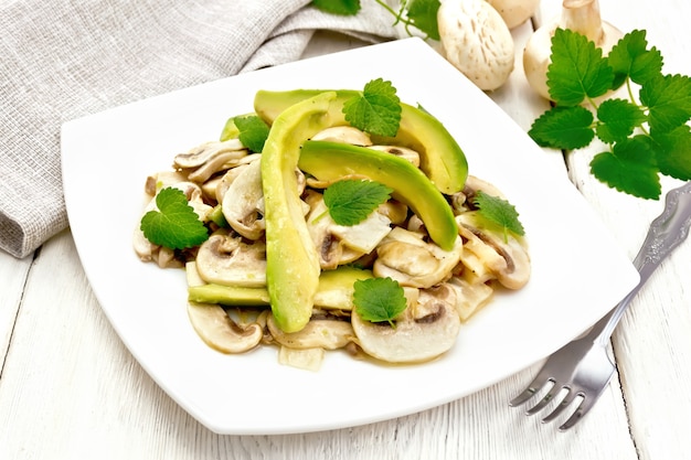 Ensalada de aguacate y champiñones crudos, sazonada con jugo de limón y aceite vegetal