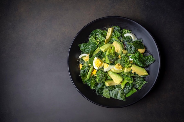 Ensalada de aguacate con huevo hervido de brócoli en un tazón blanco vintage sobre ensalada ligera