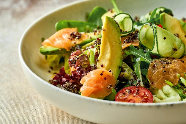 Ensalada con aguacate y salmón en un plato. primer plano, enfoque selectivo