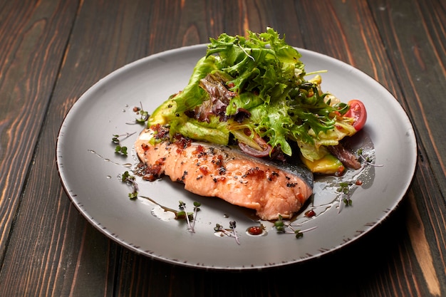 Ensalada de aguacate y salmón, sobre un fondo de madera