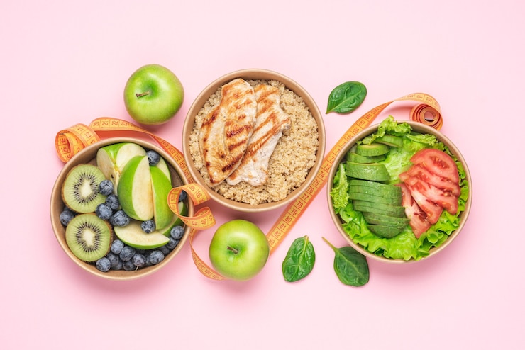Foto ensalada de aguacate vegetal, quinua con pechuga de pollo, frutas y bayas sobre fondo rosa