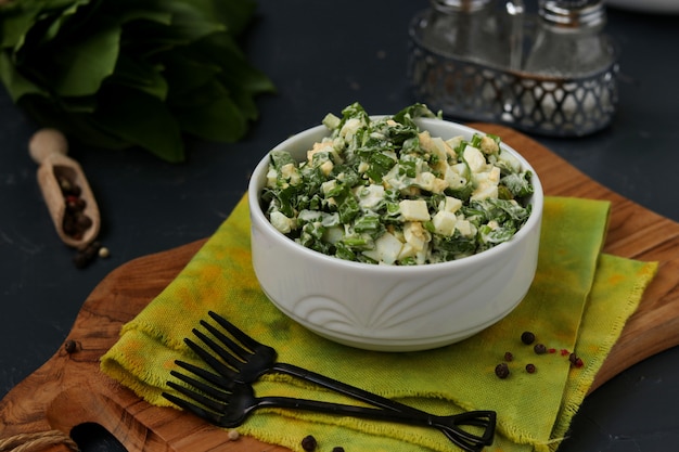 Ensalada con ajo silvestre ramson, huevos y mayonesa en un tazón blanco