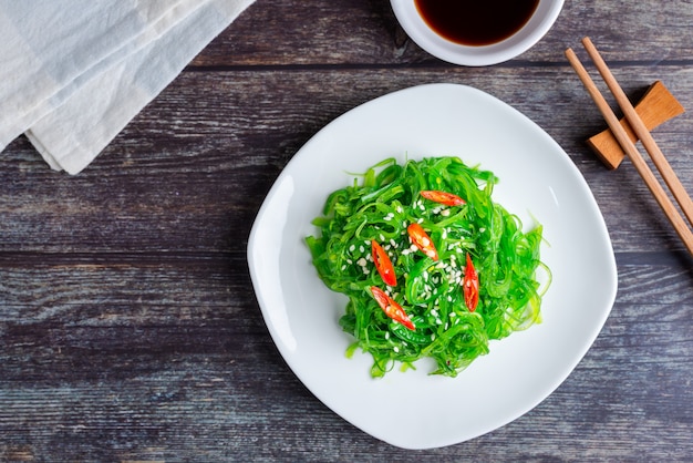 Foto ensalada de algas frescas con salsa de soja y sésamo blanco, comida vegetariana saludable. vista superior con espacio de copia.