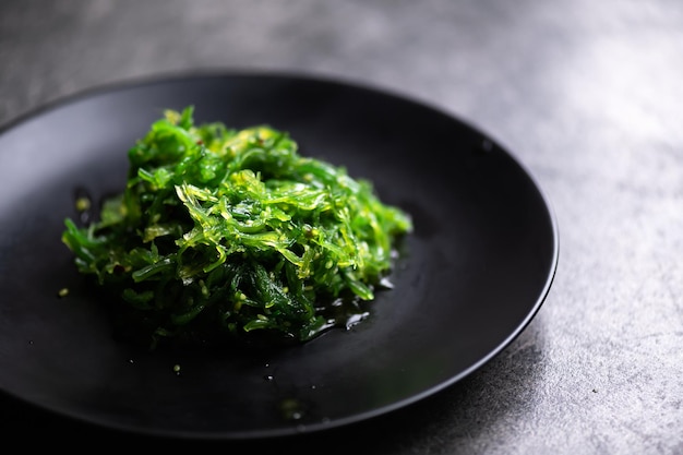 Ensalada de algas en plato negro