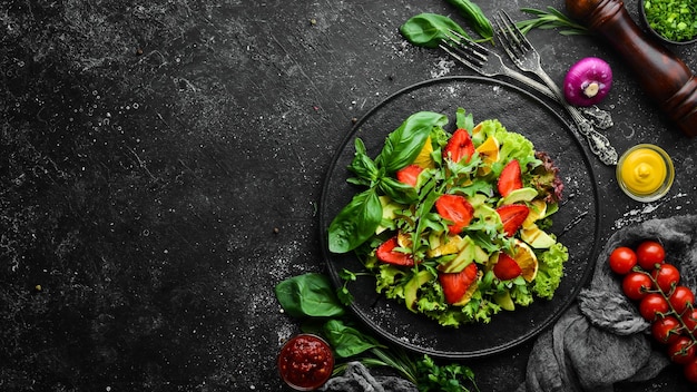 Ensalada de alimentos saludables de rúcula aguacate fresa y naranja Vista superior Espacio libre para su texto