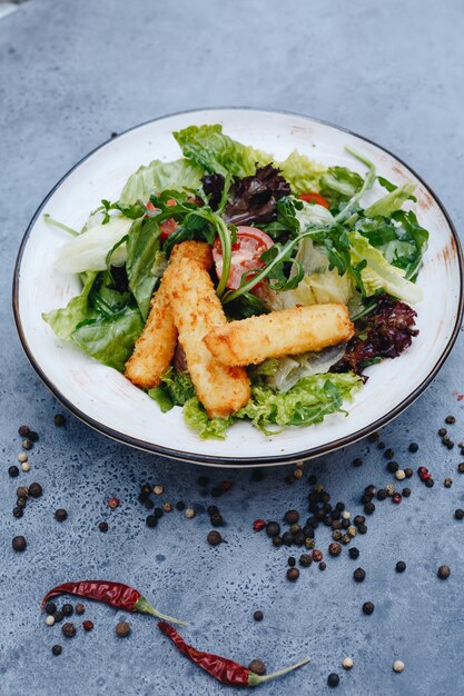 Ensalada apetitosa con queso frito y hierbas.