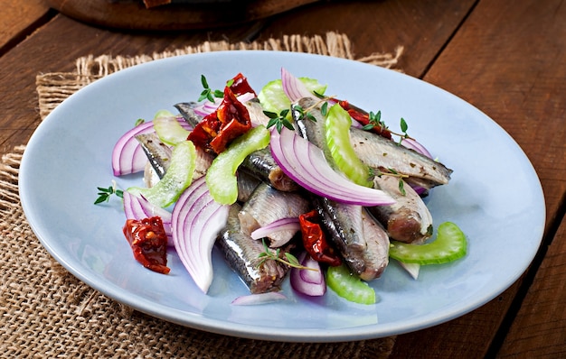 Ensalada de arenque con tomates secados al sol, apio y cebolla roja