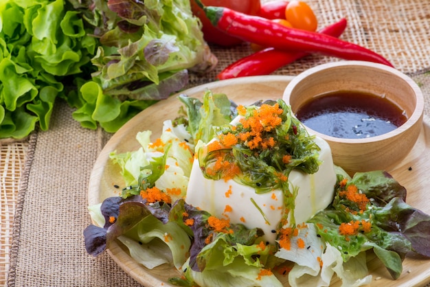 Ensalada asiática con tofu y verduras frescas Sashimi de pescado en rodajas mixtas, salmón de carne cruda en rodajas finas, atún, Sashimi es un alimento tradicional japonés de pescado crudo.