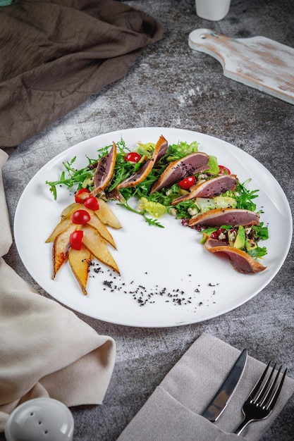 Ensalada de atún, aguacate, rúcula, pera confitada y tomates cherry.