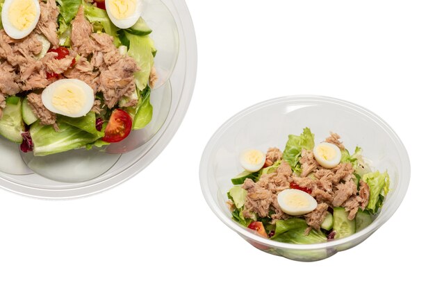 Ensalada de atún fresco con lechuga, pepinos, cerezas y huevos en recipiente de plástico. Vista superior.