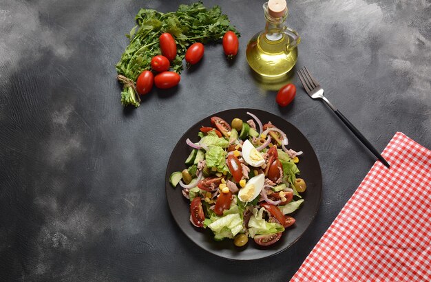 Ensalada de atún con lechuga, huevos y tomates, pepino, maíz y cebolla morada